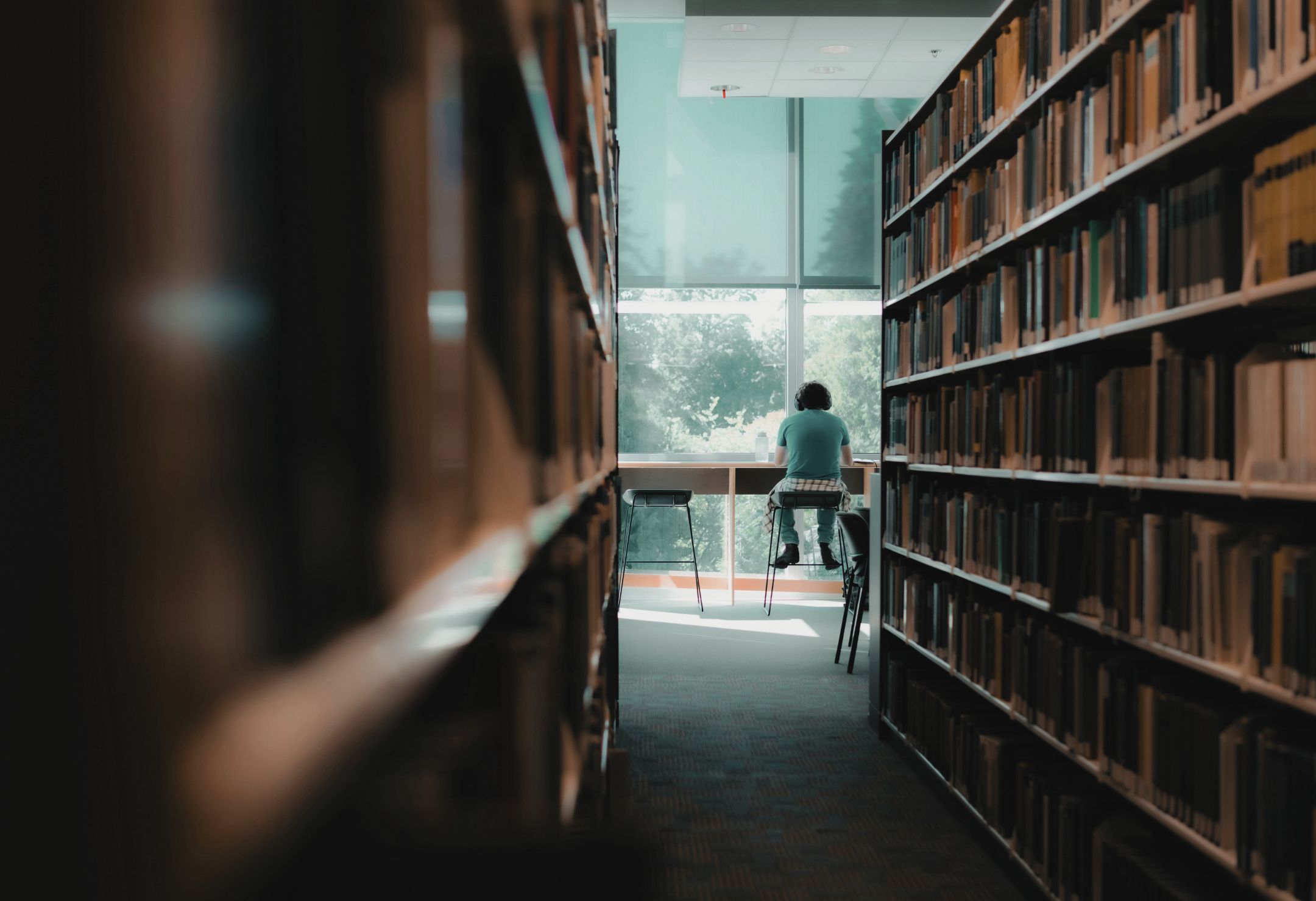 Un étudiant travaille dans une bibliothèque universitaire, symbolisant l’évaluation de la recherche et l’engagement de DORA pour des pratiques responsables.