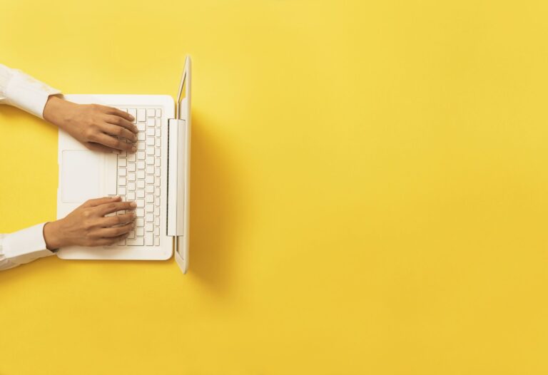 Offre d’emploi Responsable du bureau à la FQPPU – mains tapant sur un clavier d’ordinateur portable, symbolisant le travail administratif et de gestion.