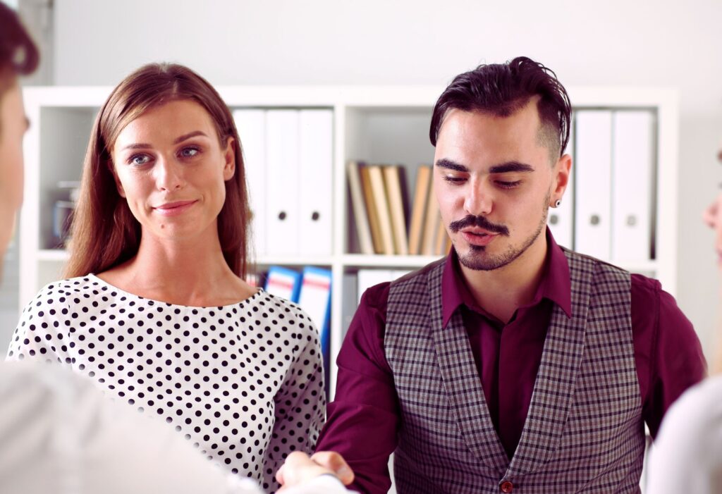 Deux personnes en discussion professionnelle dans un bureau, illustrant la collaboration et la collégialité universitaire en milieu académique.
