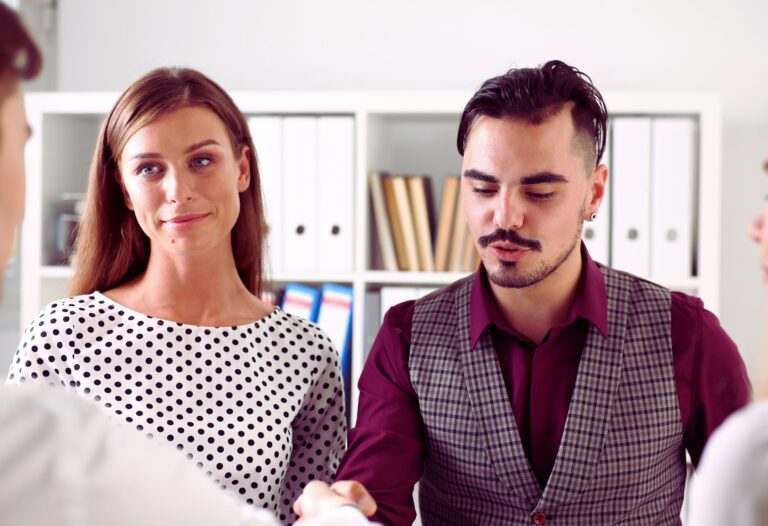 Deux personnes en discussion professionnelle dans un bureau, illustrant la collaboration et la collégialité universitaire en milieu académique.