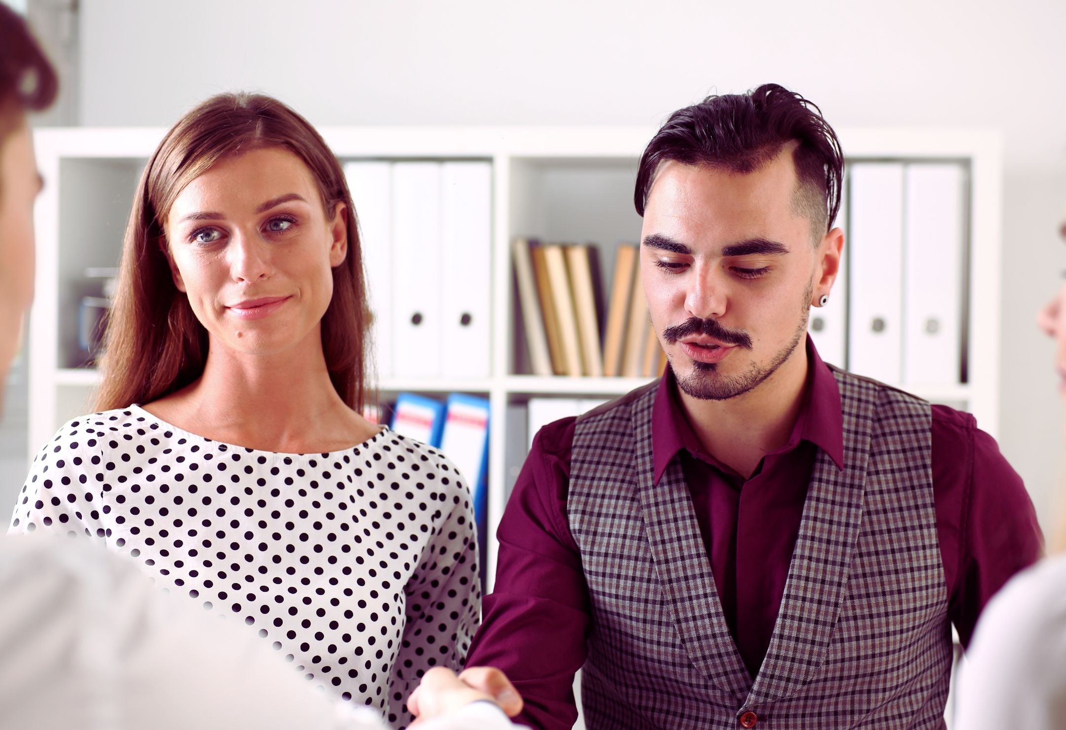 Deux personnes en discussion professionnelle dans un bureau, illustrant la collaboration et la collégialité universitaire en milieu académique.