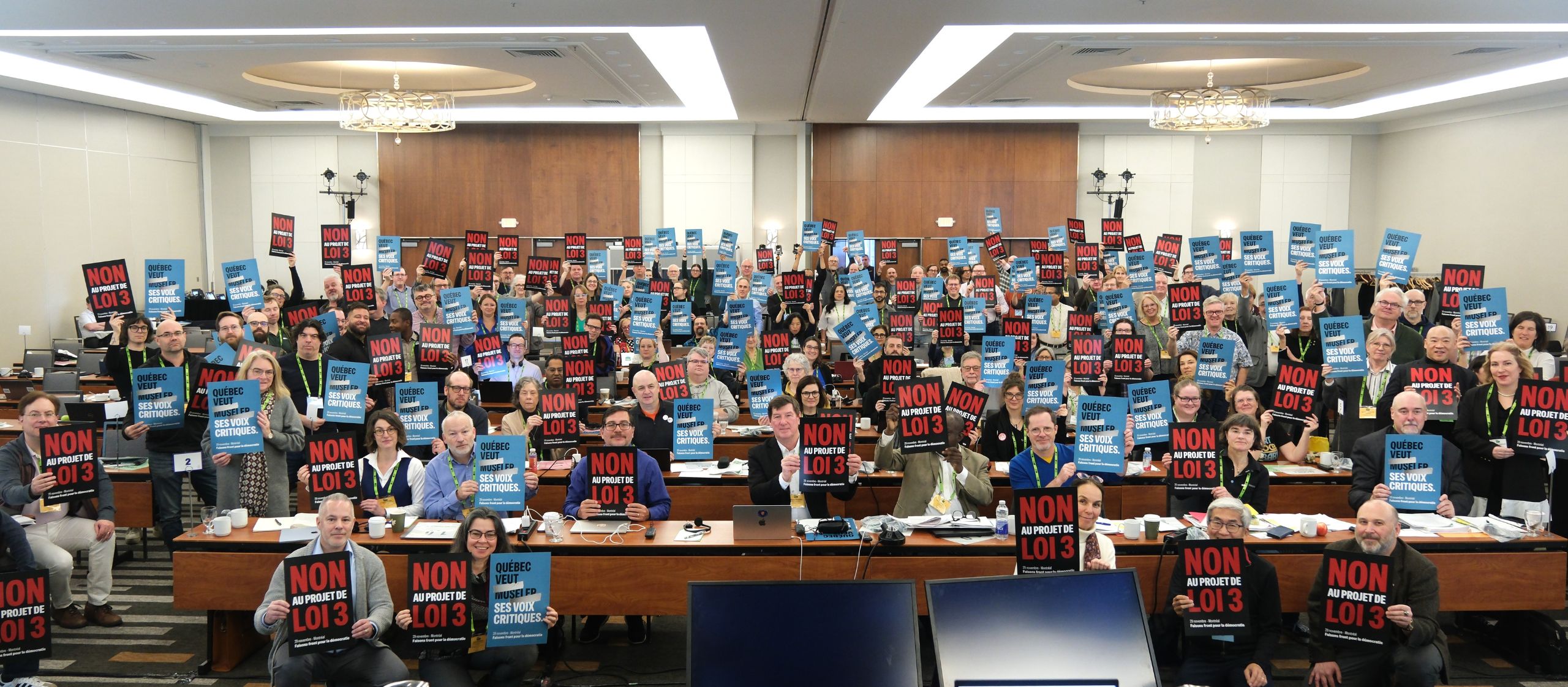 Membres du Conseil de l’ACPPU tenant des pancartes contre le projet de loi 3 lors de l’adoption unanime d’une résolution en appui aux syndicats du Québec.