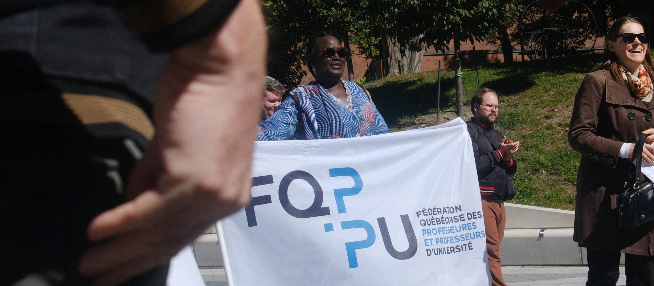 Fasal Kanouté, vice-présidente à la FQPPU, tient une bannière à la mobilisation universitaire du 22 septembre.